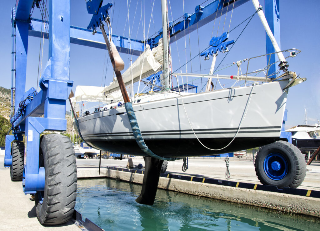 marina service lifting yacht out of water in cleaning preparation