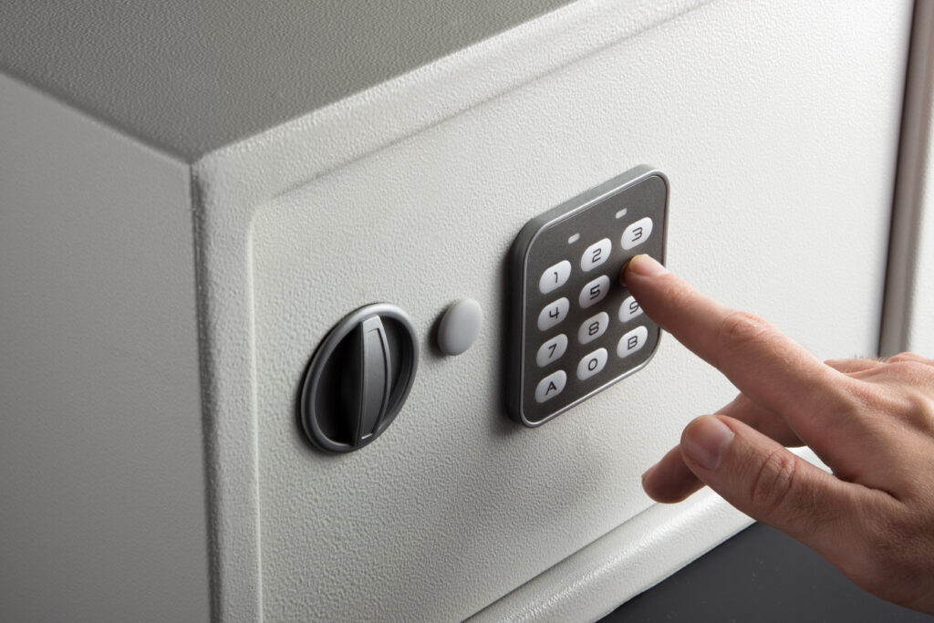 close up of hand typing in code to a home safe